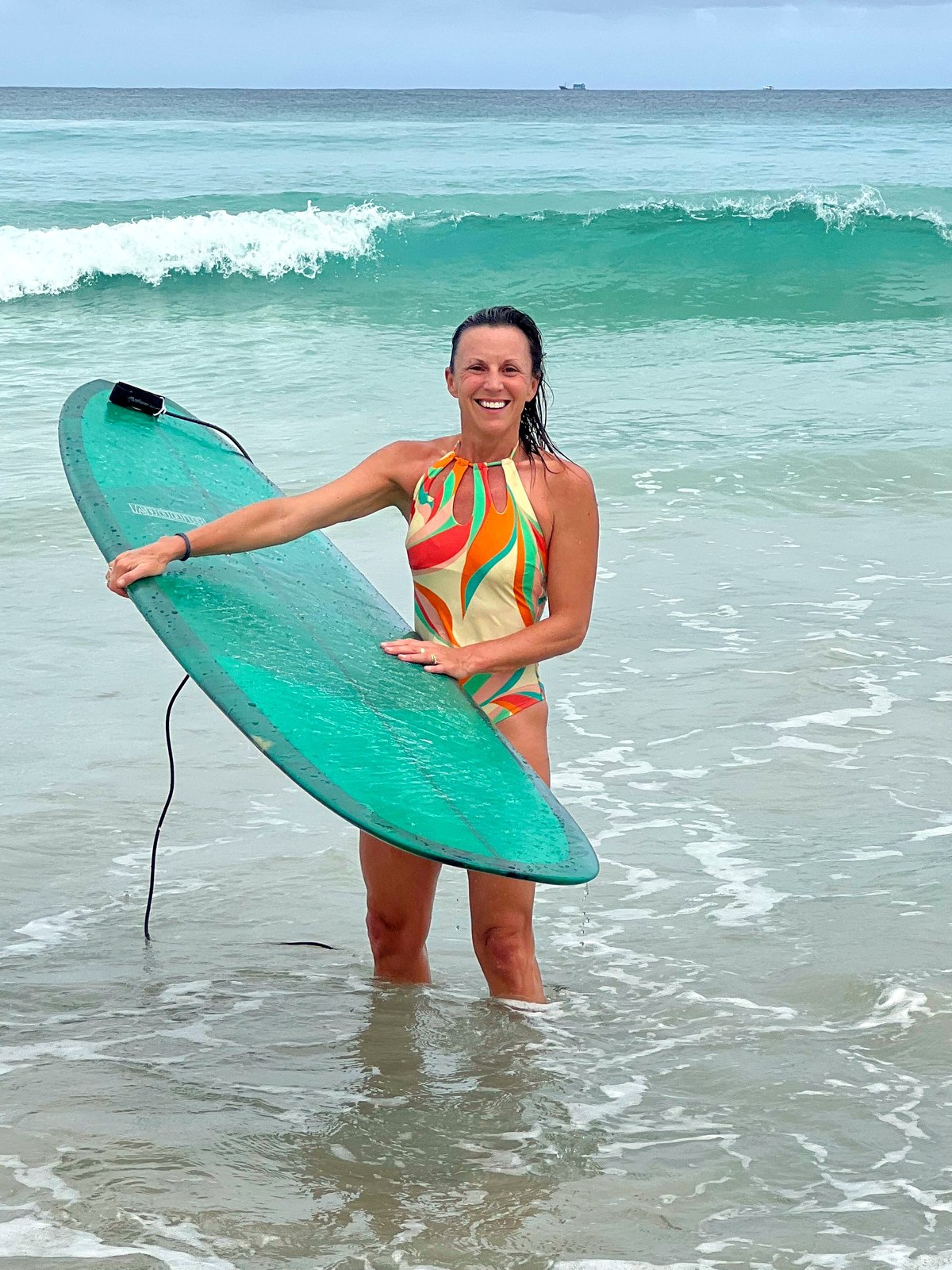 Jen Gauvin Smith in the shallows with her longboard